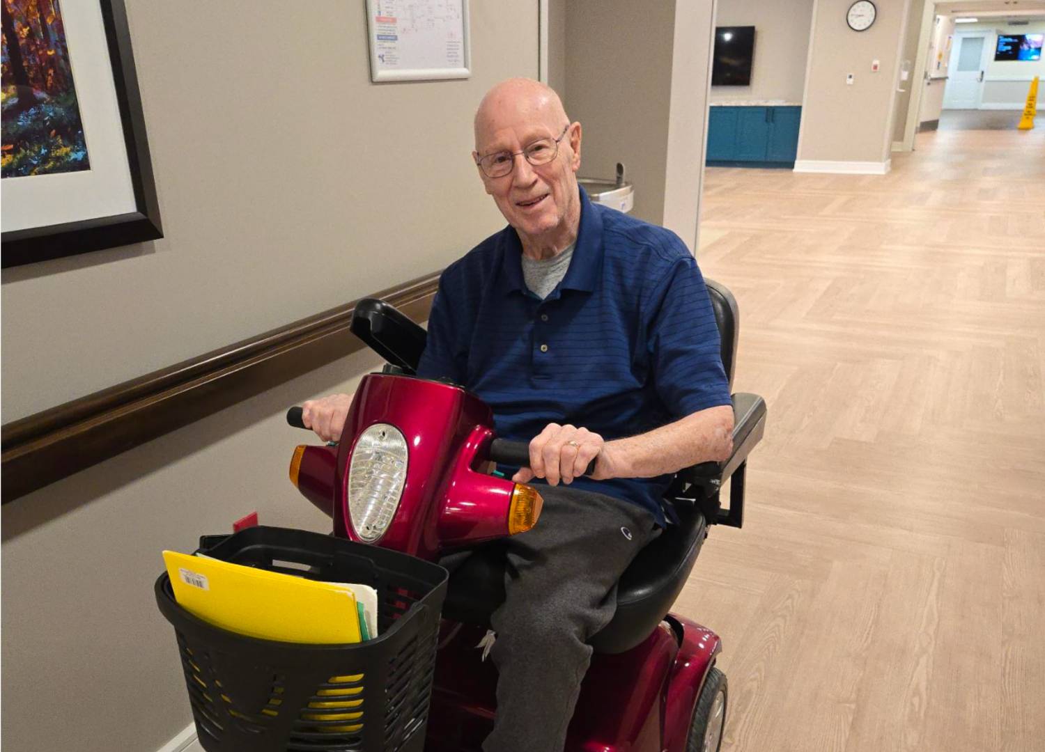 Medical Lending closet recipient on using riding cart smiling